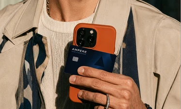 A person holding a phone and an Ampere card